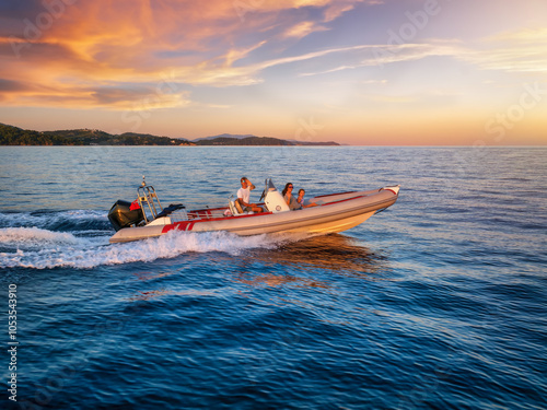 Sticker A happy family on a RIB motorboat enjoys a summer sunset cruise during their hol