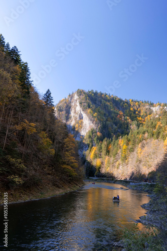 Wooden raft filled with tourists floating on the Dunajec river in the Pieniny National Park. The Dunajec Gorge in autumn. Mountains. Traditional rafting . Szczawnica, Poland photo