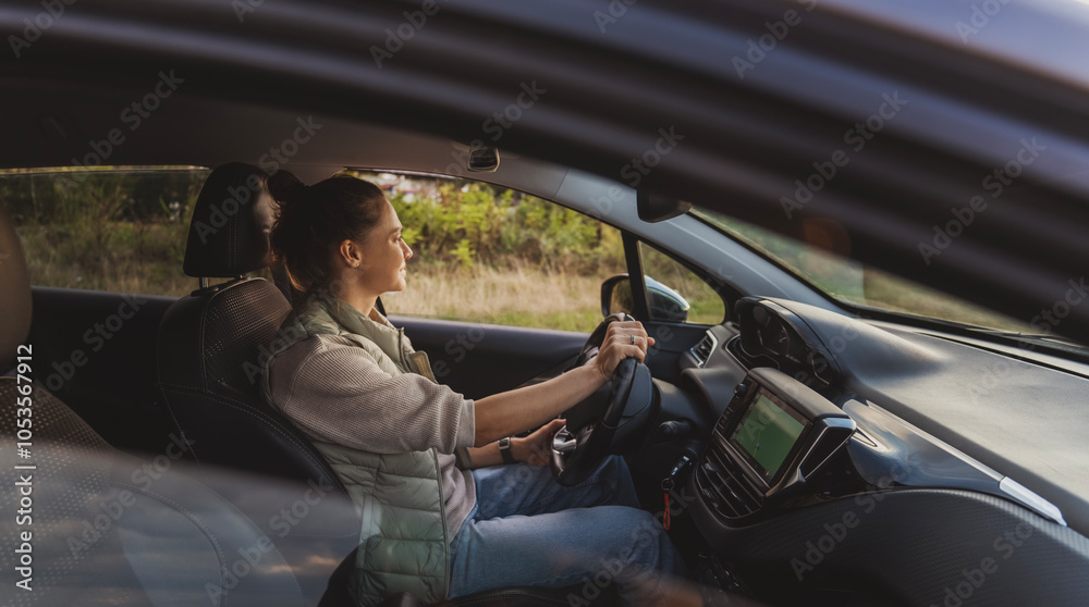 Happy young woman drivier looking out of car window, auto travel and adventure