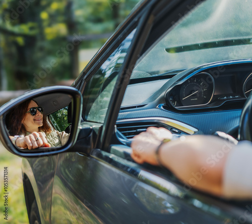 Obraz na płótnie Reflection of happy in side mirror of car young woman driver sitting behind the wheel of car w salonie