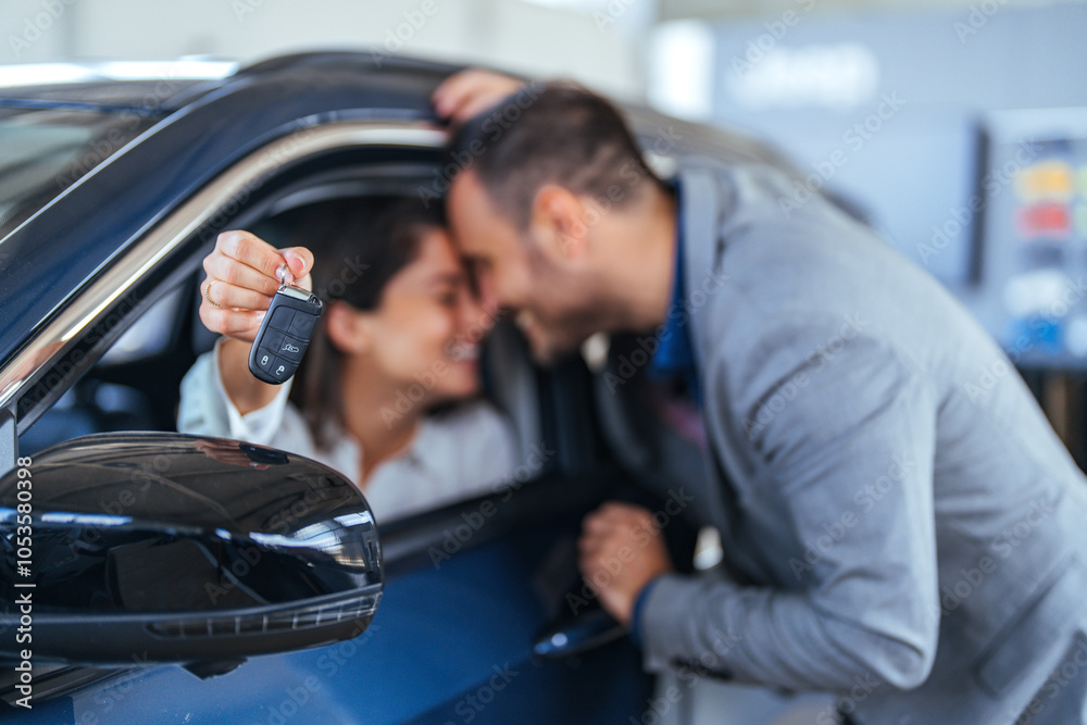 Happy Couple Receiving New Car Keys at Dealership Happy Couple Receiving New Car Keys at Dealership