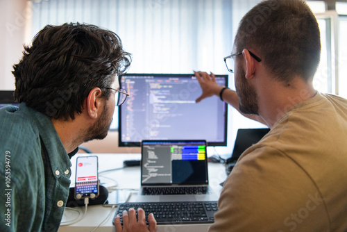 Programmers engrossed in deep collaboration, diligently working together to solve complex problems and develop innovative mobile applications with seamless functionality.