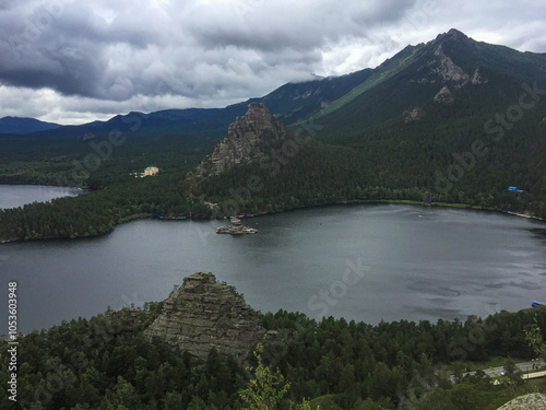 Mountain lake with rocky formations under cloudy sky
 photo