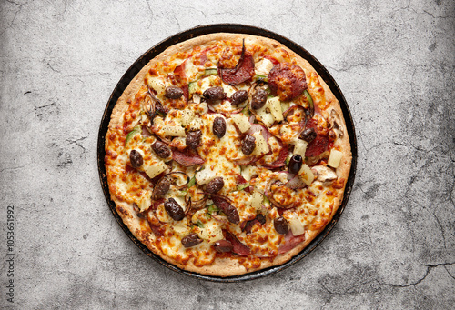 Unsliced pizza on a black pan
