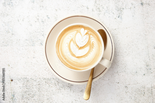Flat white on saucer with gold spoon