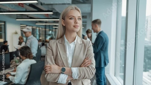 Wallpaper Mural A confident woman stands in a modern office, surrounded by colleagues engaged in work. Torontodigital.ca