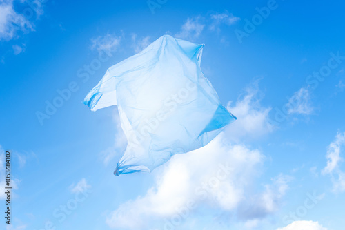 plastic environmental pollution, plastic waste in nature: disposable carrier plastic shopping bag in blue sky