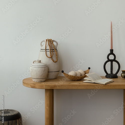 Interior design of boho home office place with wooden console, decorations, candle, personal accessories and copy space. white wall. Template.	