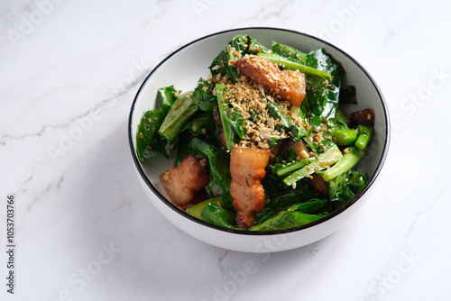 Pork stir-fry with green leafy vegetables served in a bowl photo