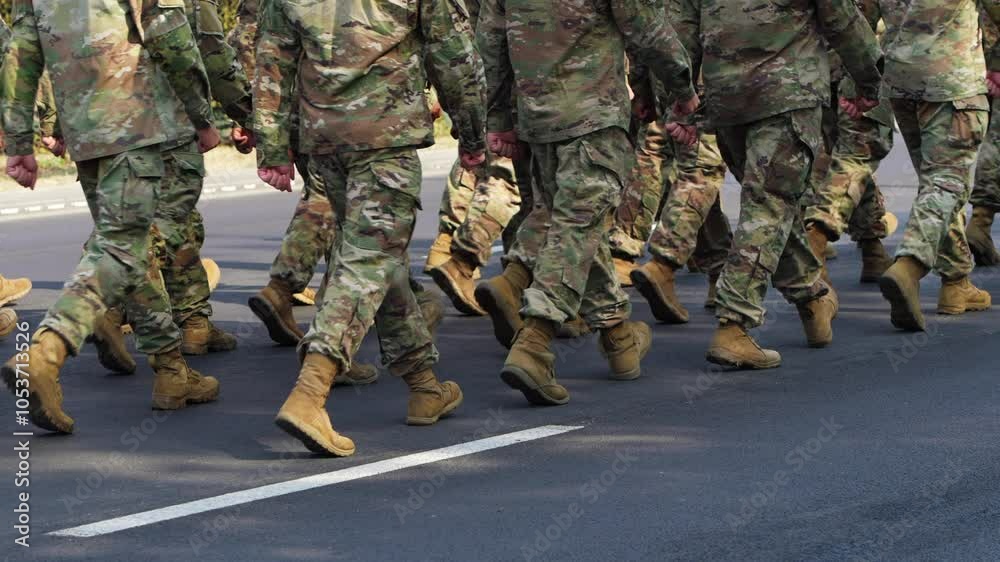 Low angle view field soldiers wearing camouflage and carrying rifles marching together on a sunny day synchronized. Military parade Low angle view field soldiers wearing camouflage and carrying rifles marching together on a sunny day synchronized. Military parade