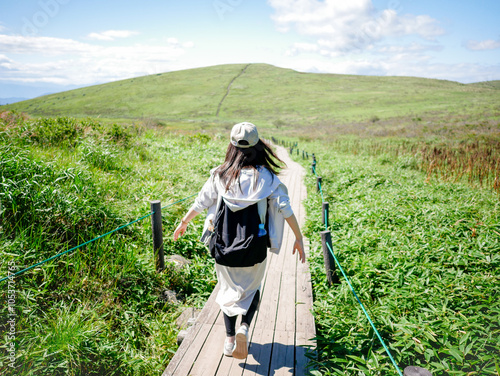 眺めの良い山を楽しそうにハイキングをする女性の後ろ姿 photo