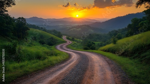 a picturesque winding road meandering through lush green hills bathed in the golden light of sunset.