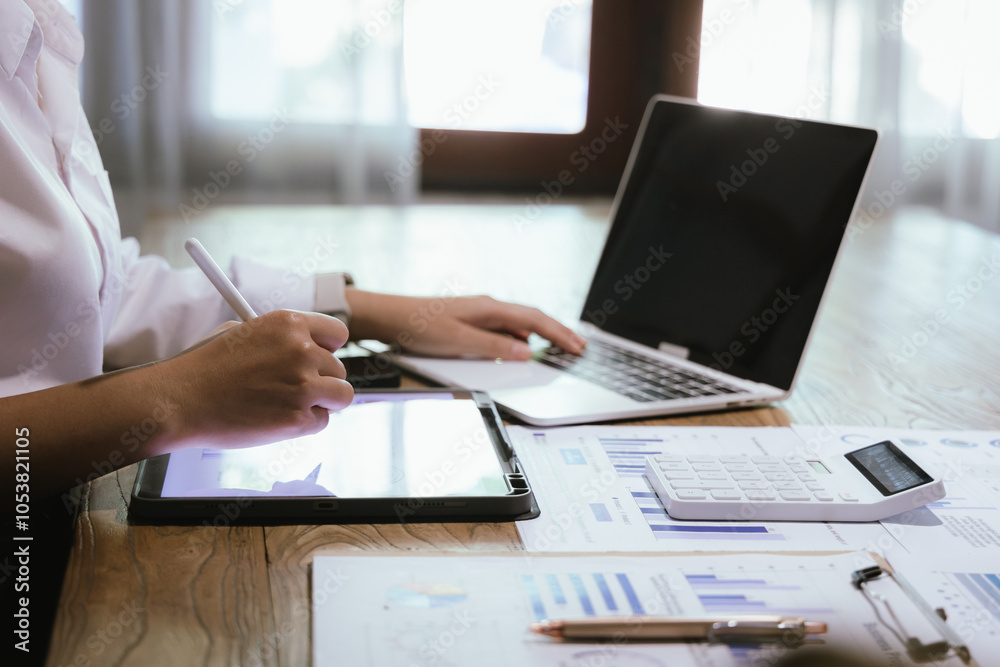 Fototapeta premium Businessman or accountant is analyzing data charts, graphs and dashboards on laptop screen to prepare statistical report.