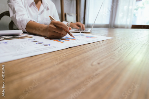 Businessman or accountant is analyzing data charts, graphs and dashboards on laptop screen to prepare statistical report.