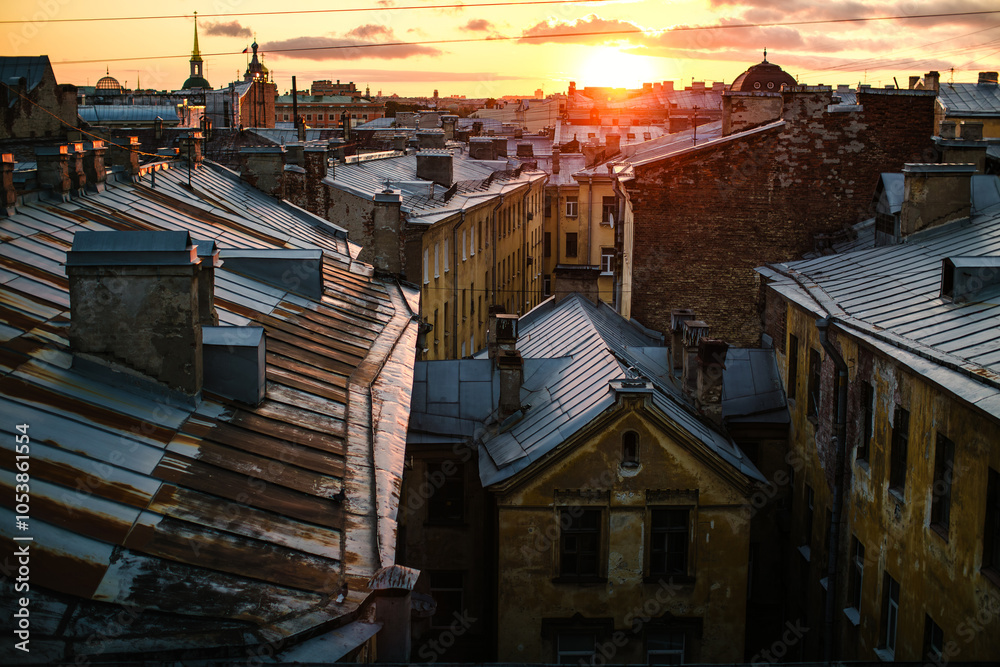 A view of Saint Petersburg rooftops at sunset, bathed in warm, golden light, capturing the romantic charm of the city's skyline.