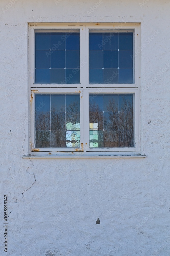 Fototapeta premium Glass window with white frame on stone wall.