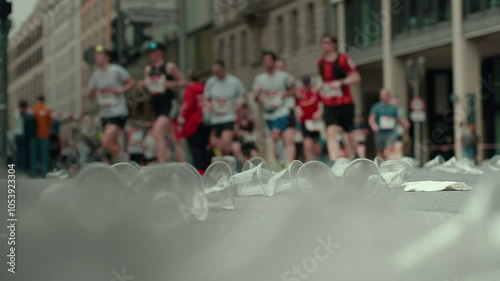 Wallpaper Mural Marathon runners creating a blur of motion, stepping amidst discarded cups at a water station, capturing the energy of a vibrant urban race scene Torontodigital.ca