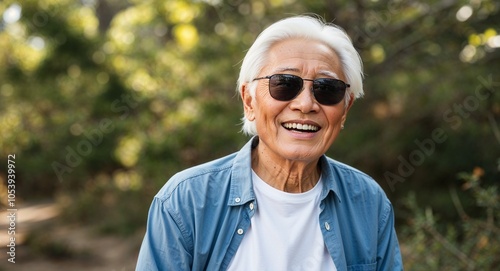 Cheerful Elderly Asian Man with White Hair in Casual Shirt and Sunglasses in Nature