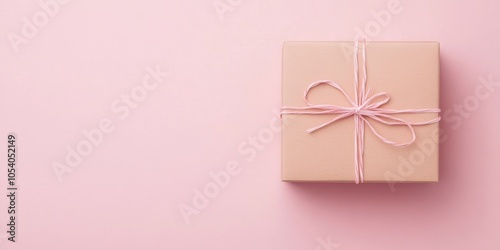 Gift box with ribbon on pink background, minimalistic and elegant design.