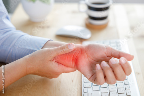 Young woman with wrist pain while using computer
