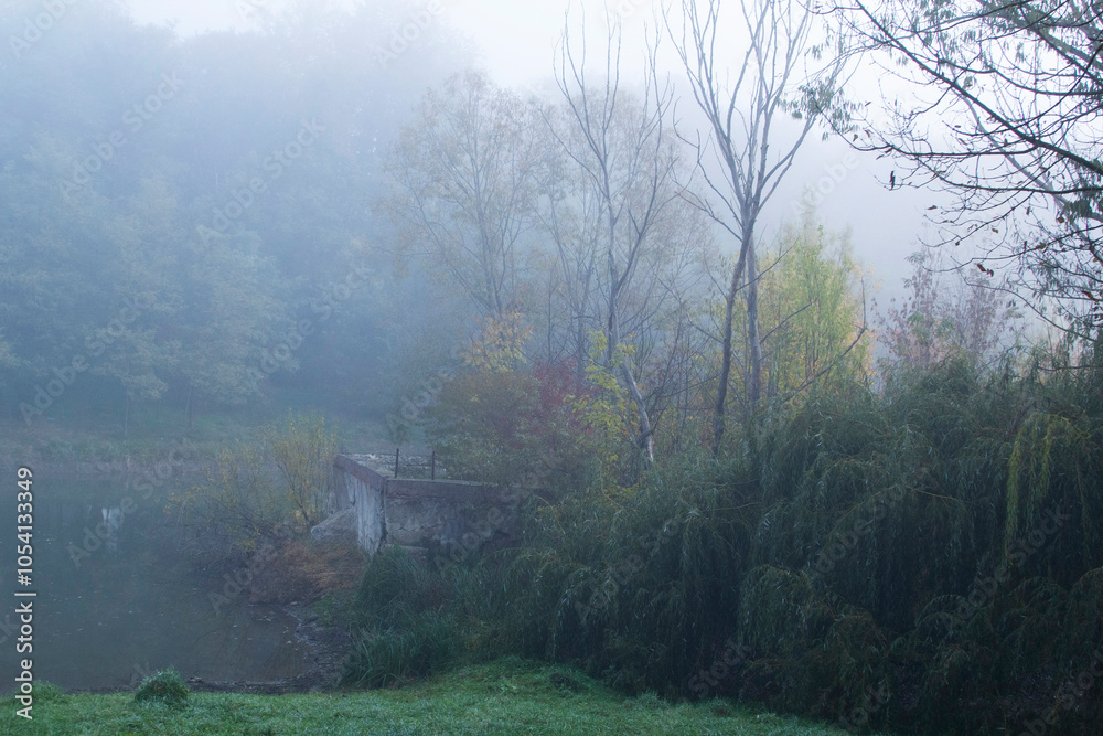 Autumn in Moldova, foggy landscape in the park. Thick fog early in the morning on the lake shore.
