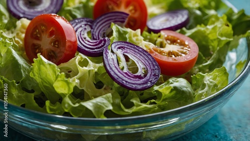 A fresh and vibrant salad featuring crisp lettuce, sliced tomatoes, and purple onions, beautifully arranged in a glass bowl. The bright colors and natural ingredients create an appetizing, healthy dis