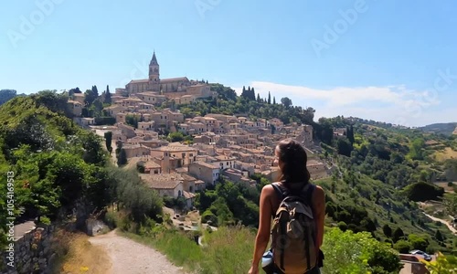 A woman is walking down a dirt road with a backpack on her back