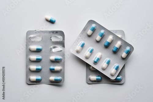 Packs of white and blue capsules of medical preparations on a white background. photo