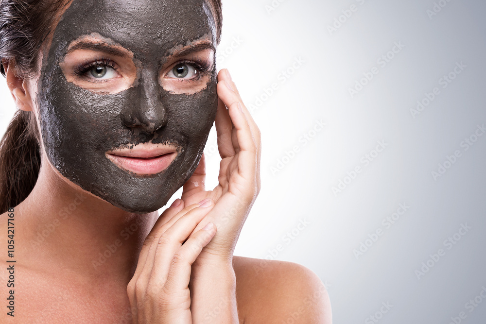 Woman Applying Black Mud Mask for Deep Facial Cleansing Woman Applying Black Mud Mask for Deep Facial Cleansing