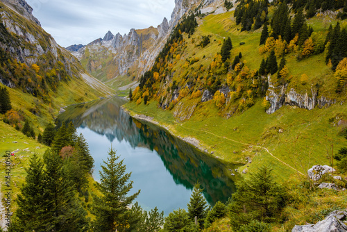 Nestled in the heart of Appenzell, Falensee glimmers with autumn colors as trees line the banks photo