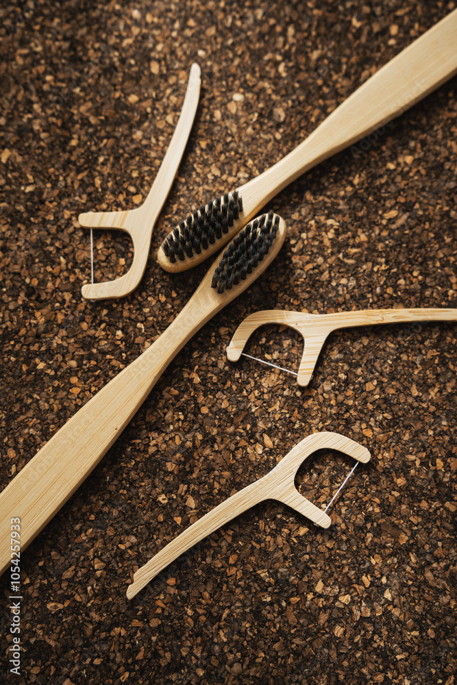 Obraz premium Bamboo Toothbrushes and Floss Picks on Cork Surface