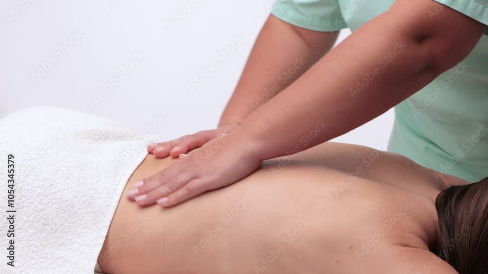 Masseur makes a relaxing massage on the neck, shoulders, back and collarbones of a young beautiful woman in a spa. Treatment for back pain. Masseur makes a relaxing massage on the neck, shoulders, back and collarbones of a young beautiful woman in a spa. Treatment for back pain.
