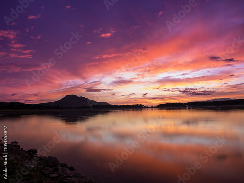 Landscape of a lake with the reflection of the mountains and clouds at autumn sunset in Granada (Spain)