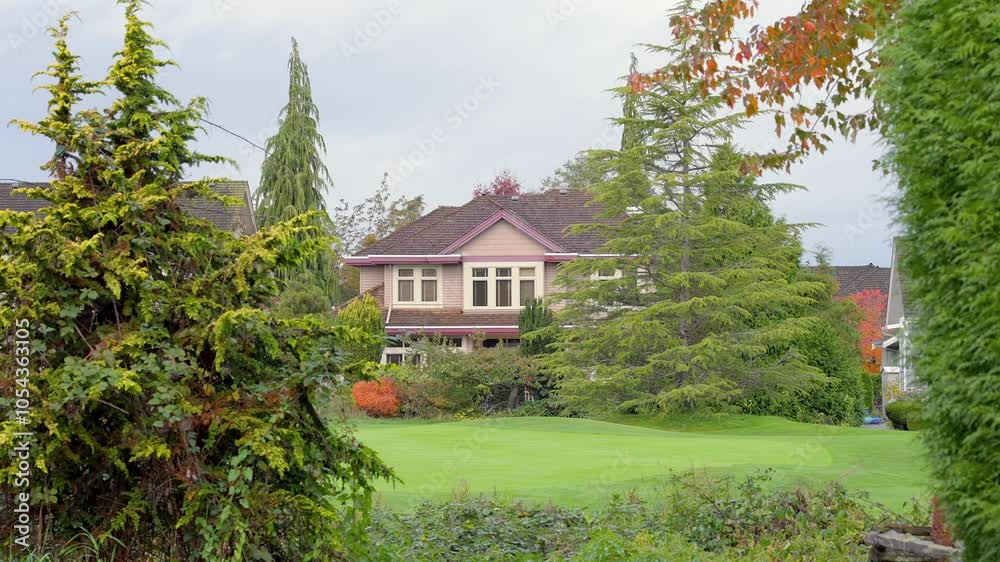 Establishing shot. Two story stucco luxury house with garage door, big tree and nice Fall foliage landscape in Vancouver, Canada, North America. Day time on Sept 2024. ProRes 422 HQ. Establishing shot. Two story stucco luxury house with garage door, big tree and nice Fall foliage landscape in Vancouver, Canada, North America. Day time on Sept 2024. ProRes 422 HQ.