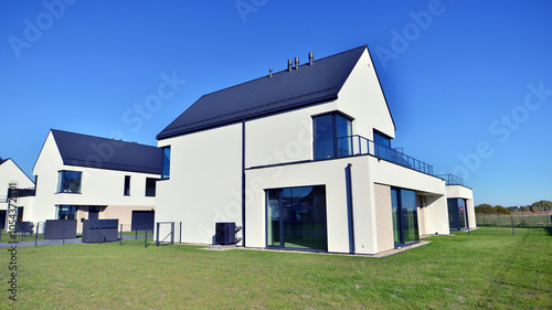 New elegant modern single family house. Terraced family homes in newly developed housing estate. Facade of a modern house with white walls. Real estate concept, european style.   photo