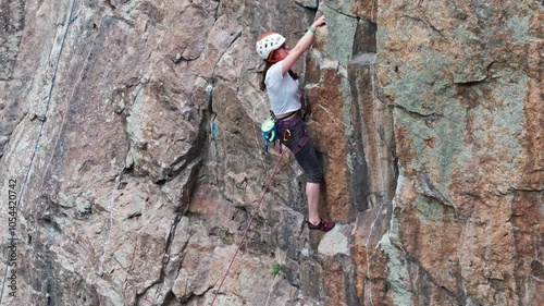 Female climber ascending challenging rock face