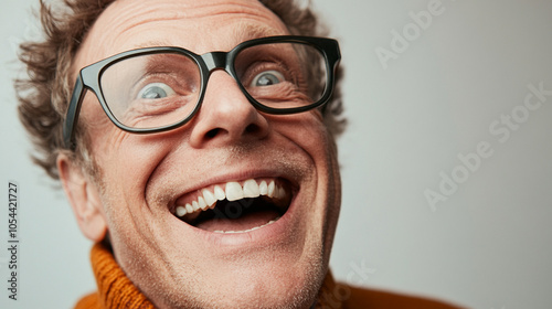 A close-up image capturing the pure joy of a mature man with glasses, laughing heartily