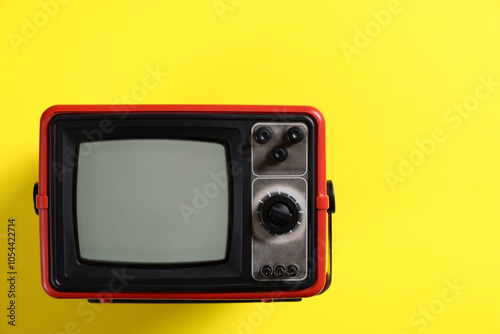 Retro tv set on yellow background, top view. Space for text