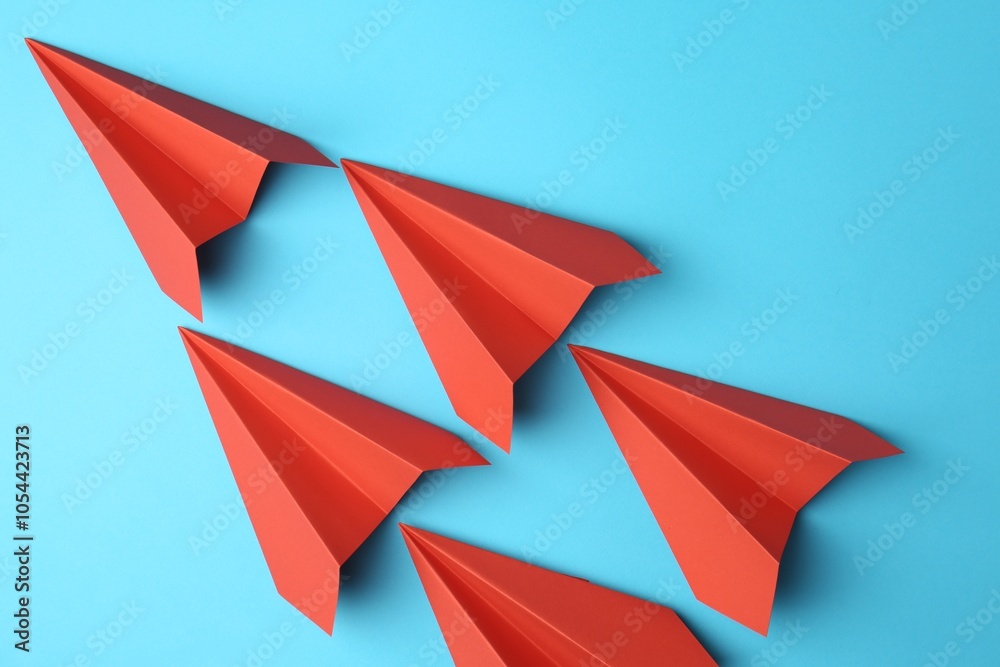 Handmade red paper planes on light blue background, top view Handmade red paper planes on light blue background, top view