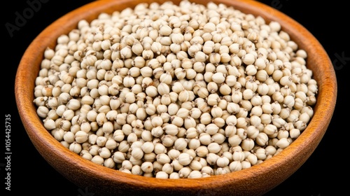 Close-up of buckwheat seeds in a rustic wooden bowl on a sleek black background, ideal for culinary inspiration or editorial use