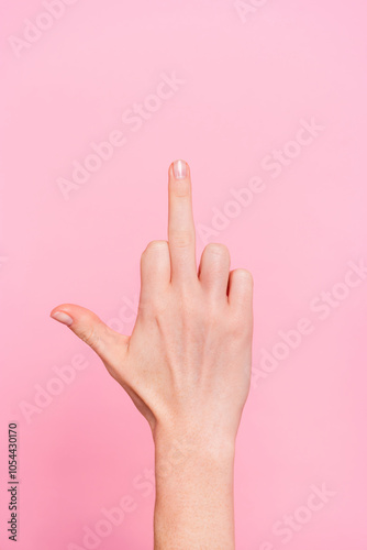 Close up cropped vertical photo of woman hand demonstrate middle finger isolated on pink color background