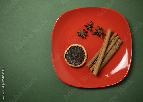 spices, cinnamon, orange on red plate photo