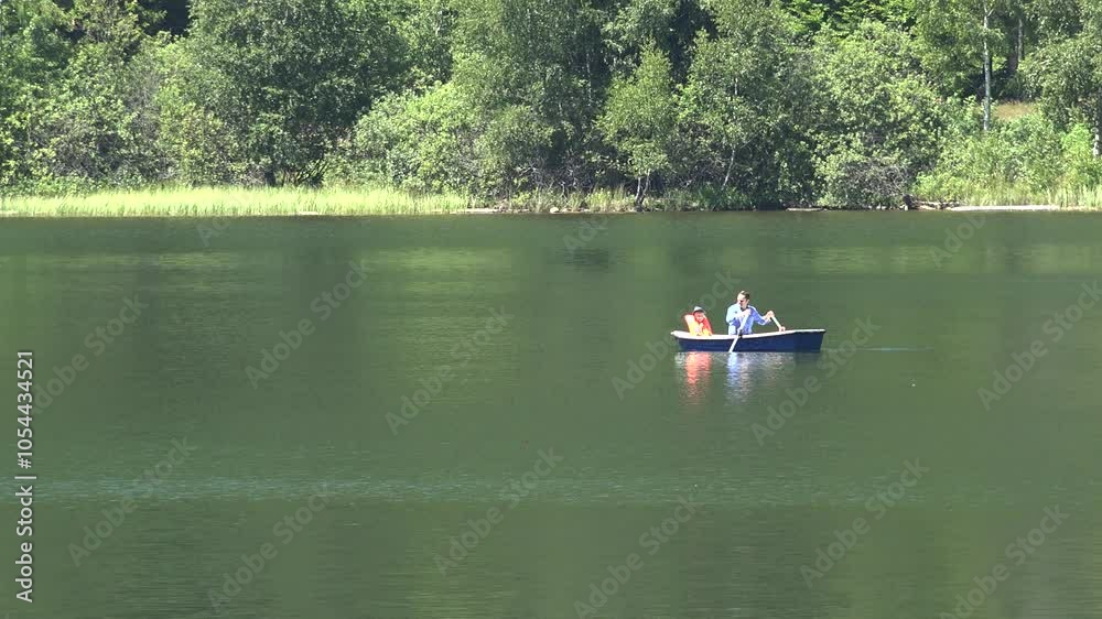 Man and child in a paddle boat on lake