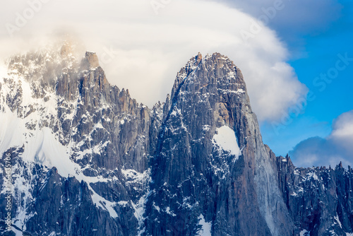The Petit Dru mountain summit displays rugged peaks and rocky formations against clear sky. Rocky peak of Aiguilles de Dru, les Drus in Chamonix Alps