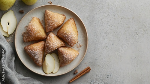 Spiced pear-filled beignets, arranged on a light ceramic plate, isolated on a gray background, with pear slices and cinnamon sticks scattered photo