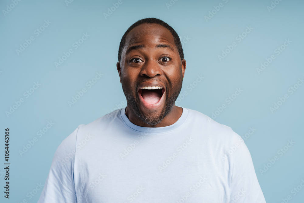 Surprised young African American man posing in studio isolated on blue Surprised young African American man posing in studio isolated on blue