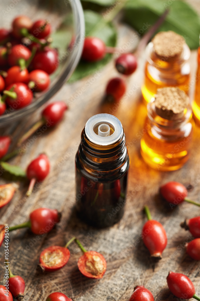 A dark bottle of rosehip seed oil with fresh rose hips