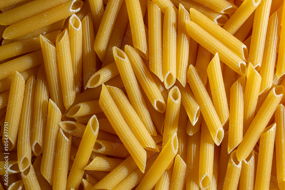 Uncooked Penne Rigate Pasta: A Culinary Canvas of Penne Macaroni, Creating a Lively and Textured Background for Gourmet Cooking. Dry Pasta. Raw Macaroni - Top View, Flat Lay Uncooked Penne Rigate Pasta: A Culinary Canvas of Penne Macaroni, Creating a Lively and Textured Background for Gourmet Cooking. Dry Pasta. Raw Macaroni - Top View, Flat Lay