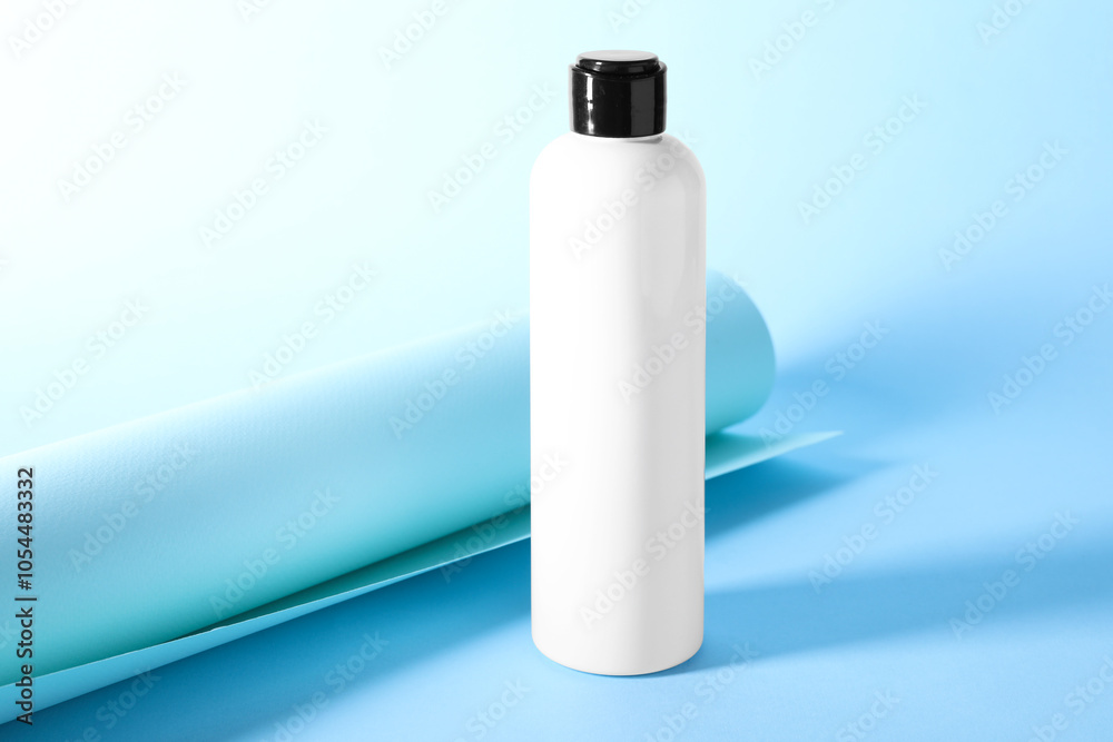 Shampoo in bottle on light blue background. Personal care product