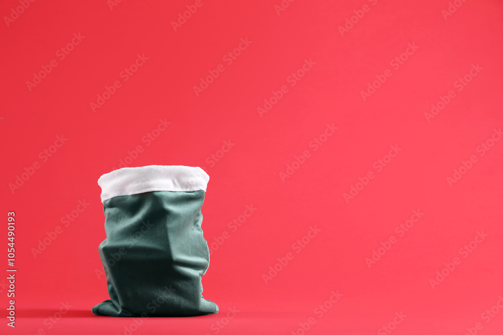 Green Santa Claus bag on red background, space for text